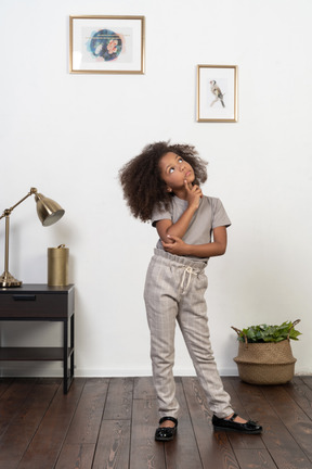 Good looking girl kid posing on the apartment background