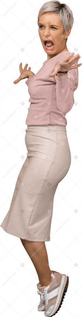 Vue latérale d'une femme émotive dans des vêtements décontractés debout avec les bras tendus