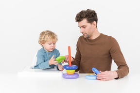 Pai e filho montando um brinquedo empilhável