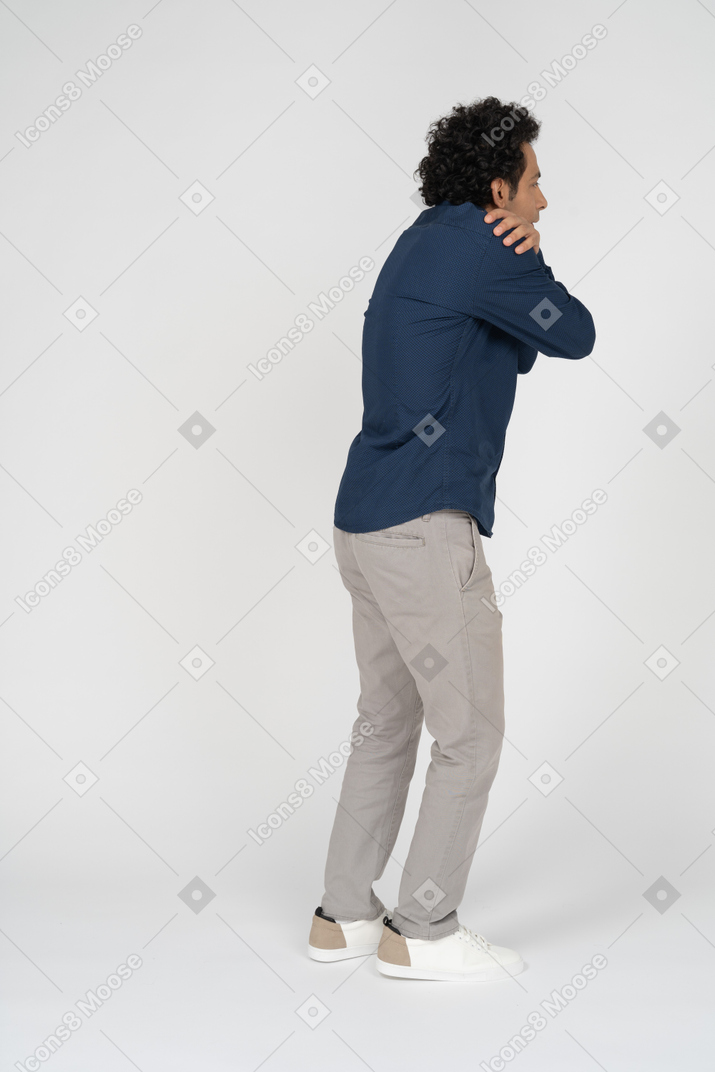 一个穿着休闲服的男人拥抱自己的侧视图