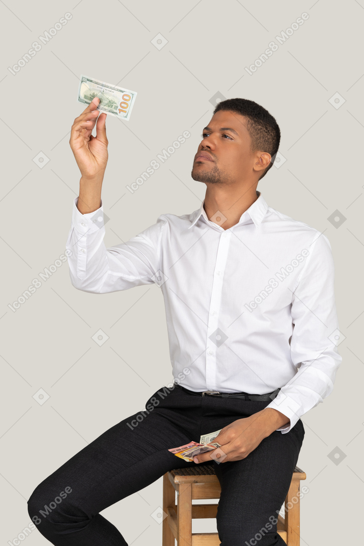 Man looking at banknote