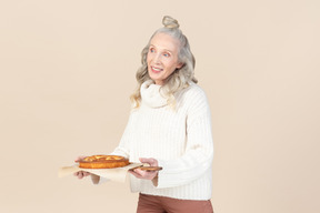 优雅的老女人提供尝试她自制的馅饼