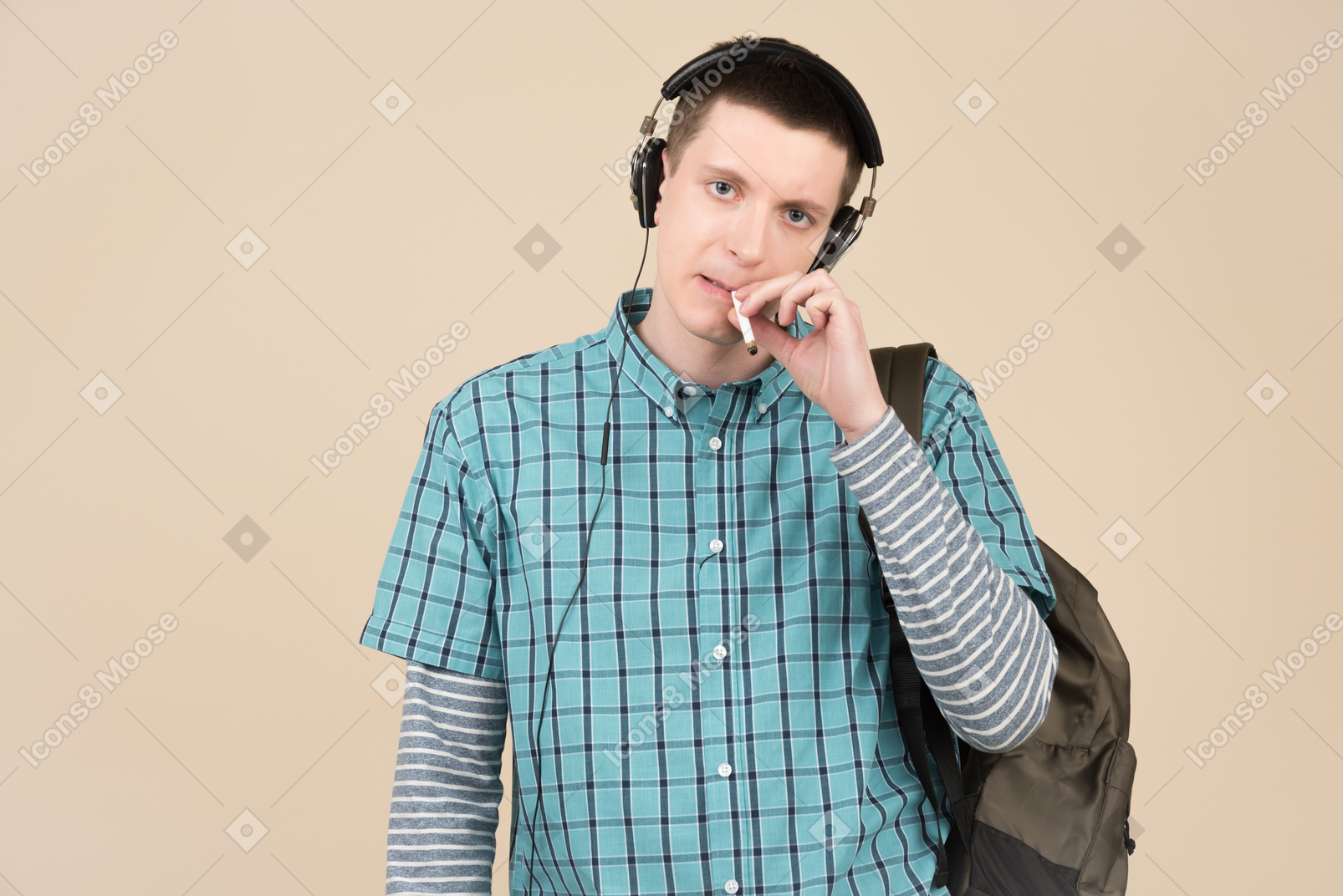 Young man smoking a cigarette and listening to music