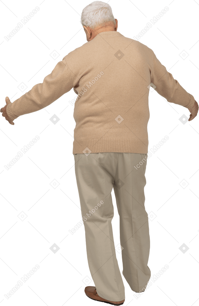 一位穿着休闲服的老人张开双臂站立的后视图