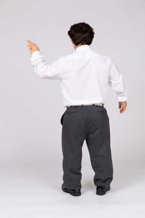 Back view of a man in business casual clothes raising his hand