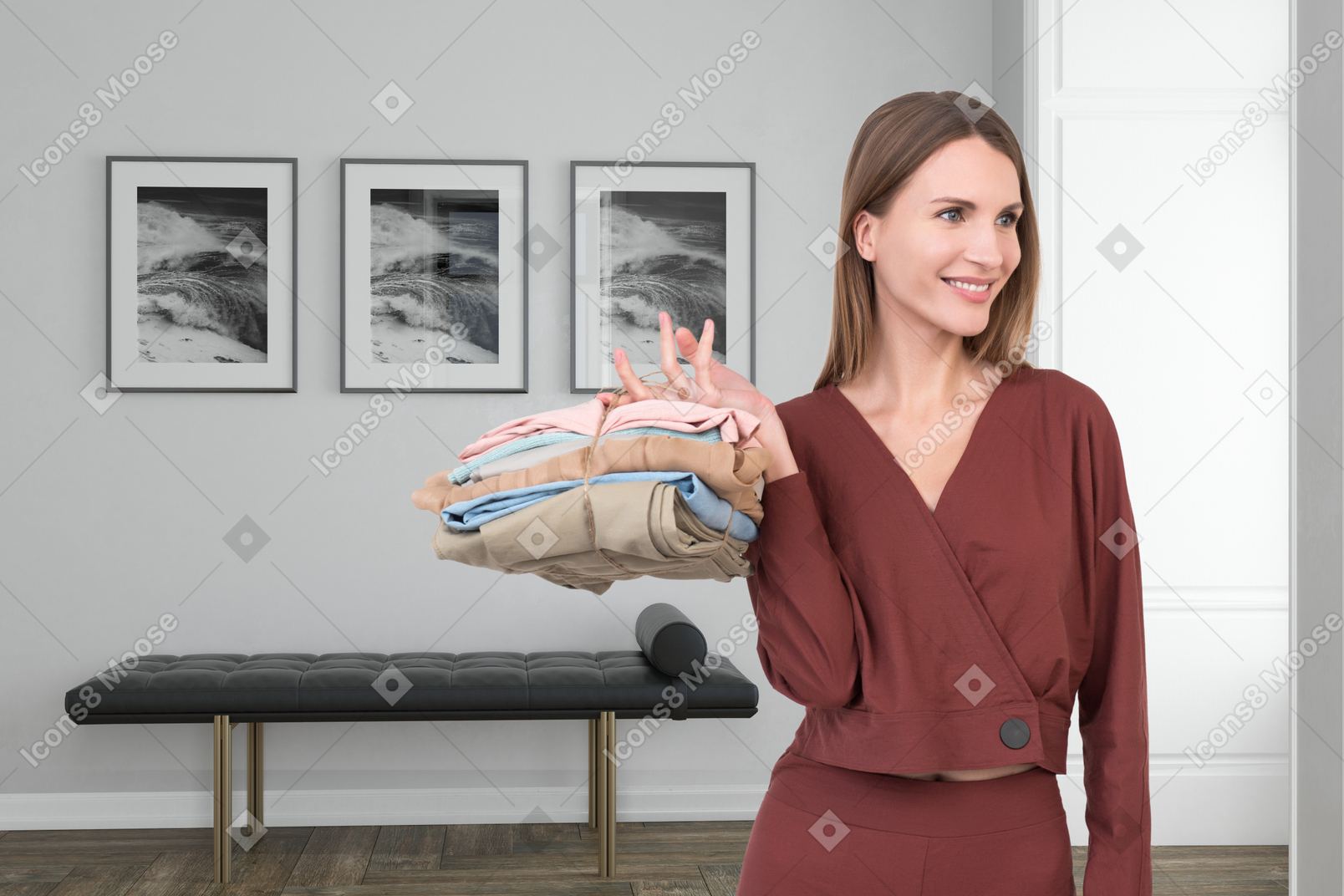 A woman holding a stack of clothes in a room