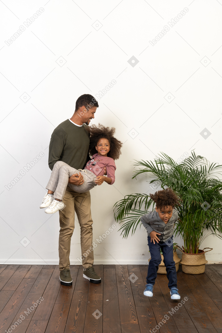 Good looking young man plays with his children