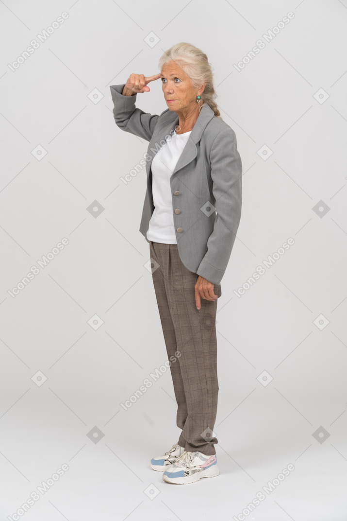 Vista lateral de una anciana en traje haciendo un gesto de soltar el tornillo