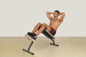 Young muscular man working out on weight bench