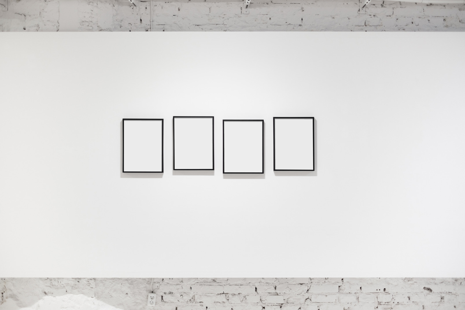 White wall with empty frames on it