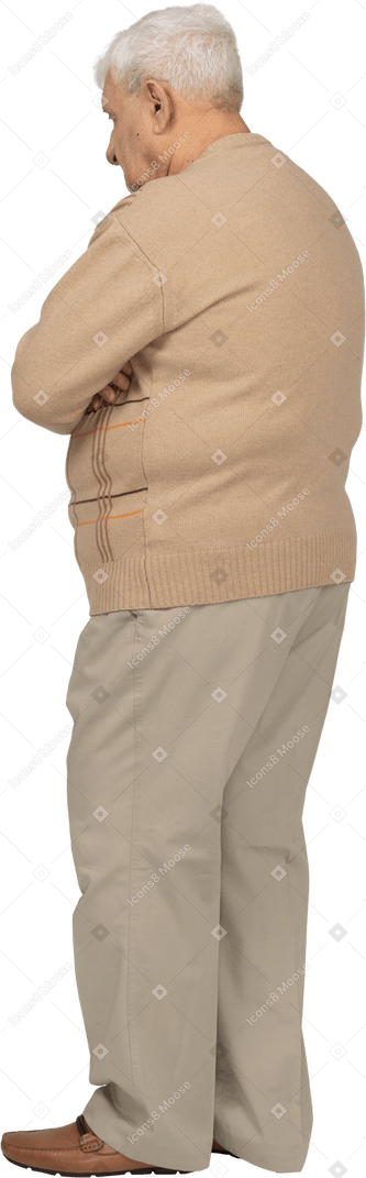 Seitenansicht eines alten mannes in freizeitkleidung, der mit verschränkten armen steht