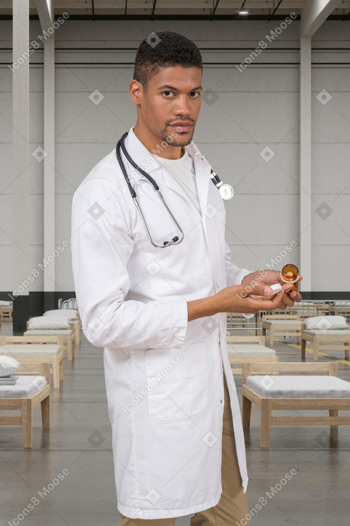 A man in a white lab coat holding pills