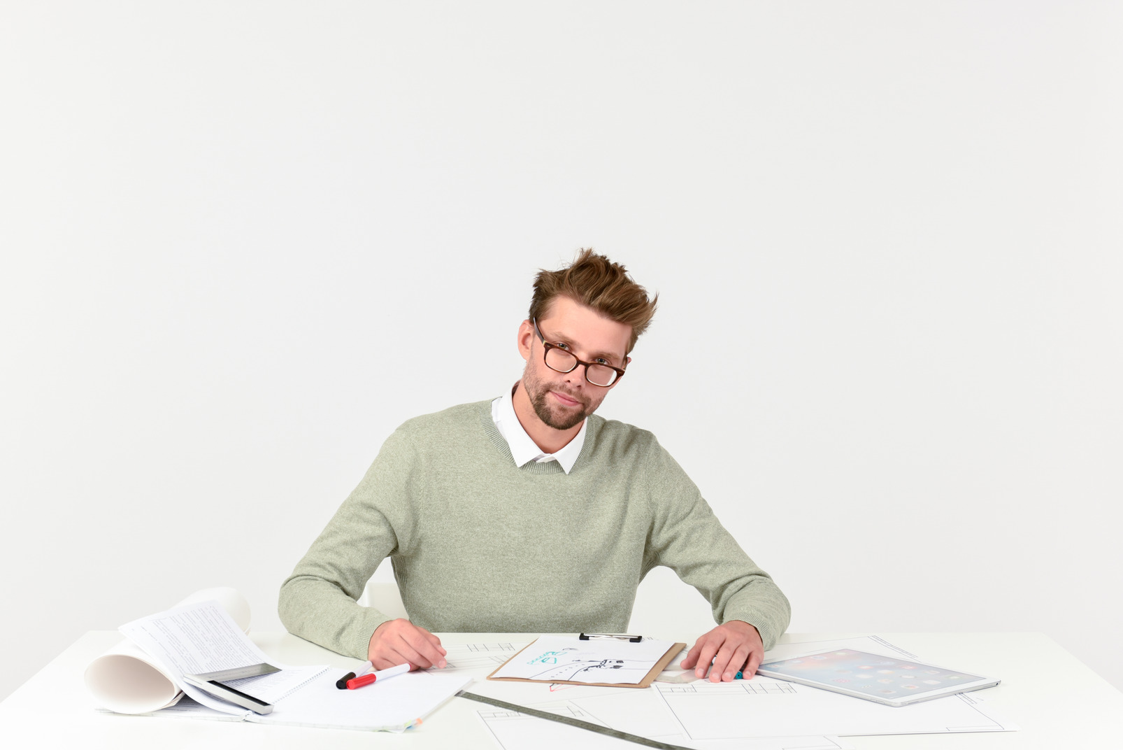 Wearing glasses male architect sitting at work desk