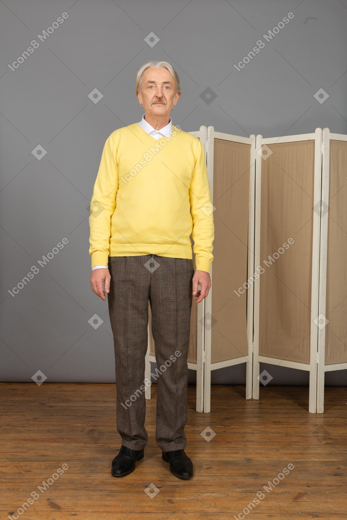 Front view of an old man standing still by the screen