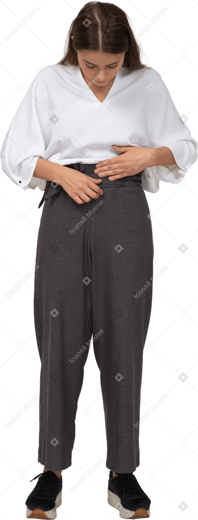 Front view of a young lady in office clothing adjusting her pants
