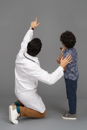 Médico mostrando algo para menino