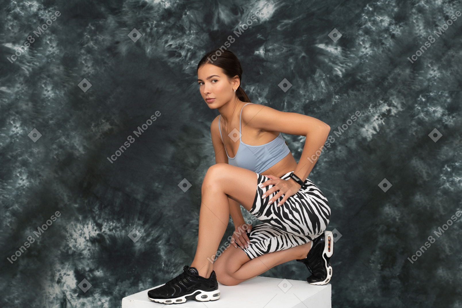 Full-length a female athlete squatting confidently leaning hip