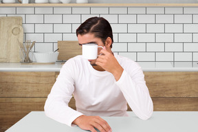 A man sitting at a table with a cup of coffee