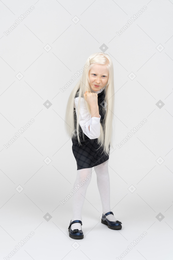 Schoolgirl looking angry and raising a fist