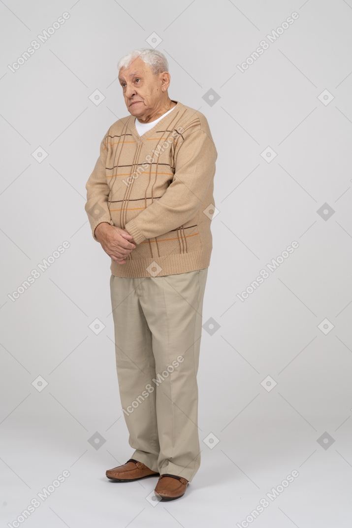 Front view of an old man in casual clothes looking up