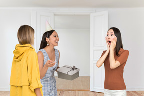 Two women surprising their friend on her birthday
