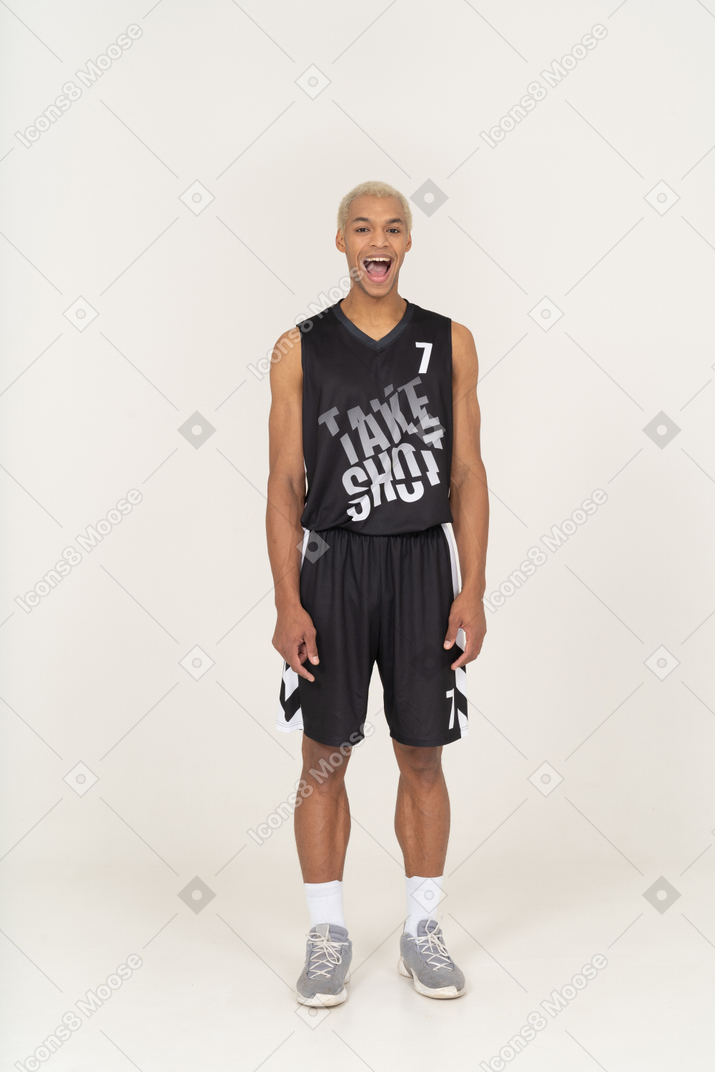 Vista frontale di un giovane giocatore di basket maschile ansimante in piedi immobile