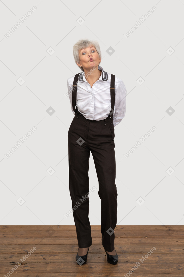 Front view of a pouting old lady in office clothing leaning forward