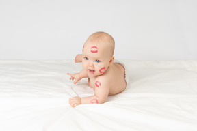 Niña sonriente con besos de lápiz labial rojo