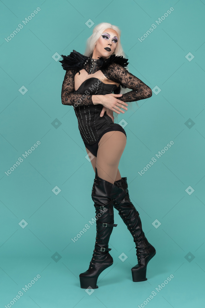 Drag queen posing and looking aside holding hand on waist