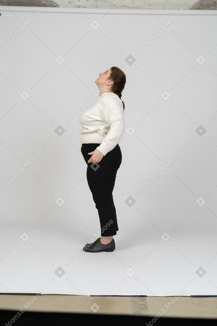 Side view of a plump woman in casual clothes posing