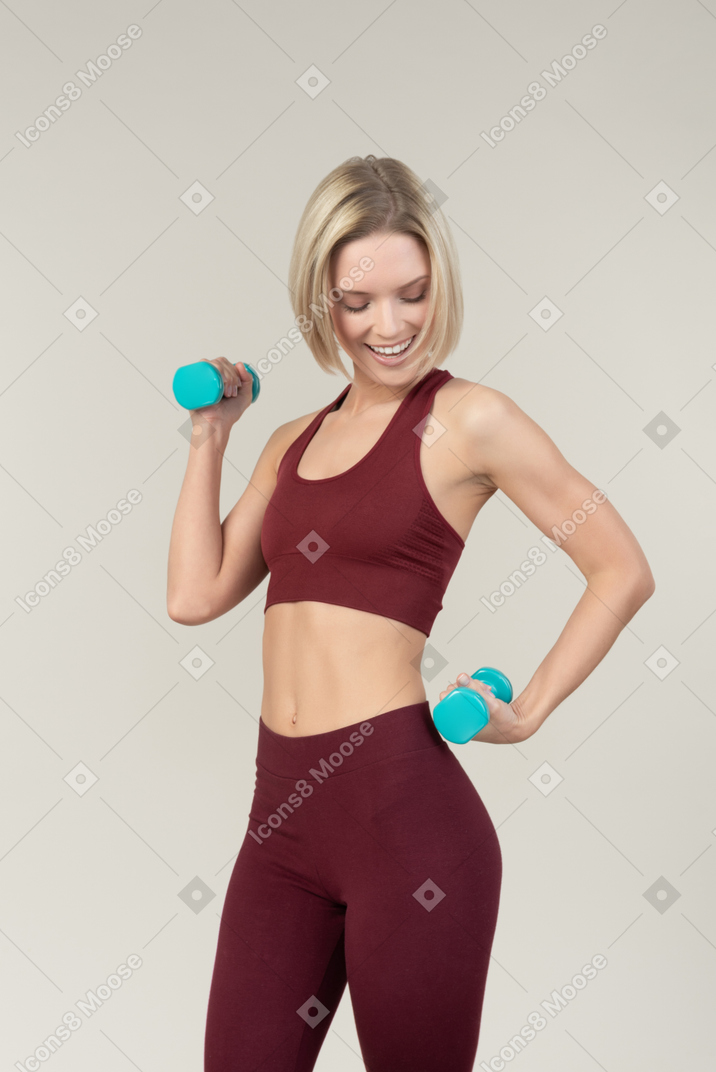 Serious looking young woman lifting hand weights