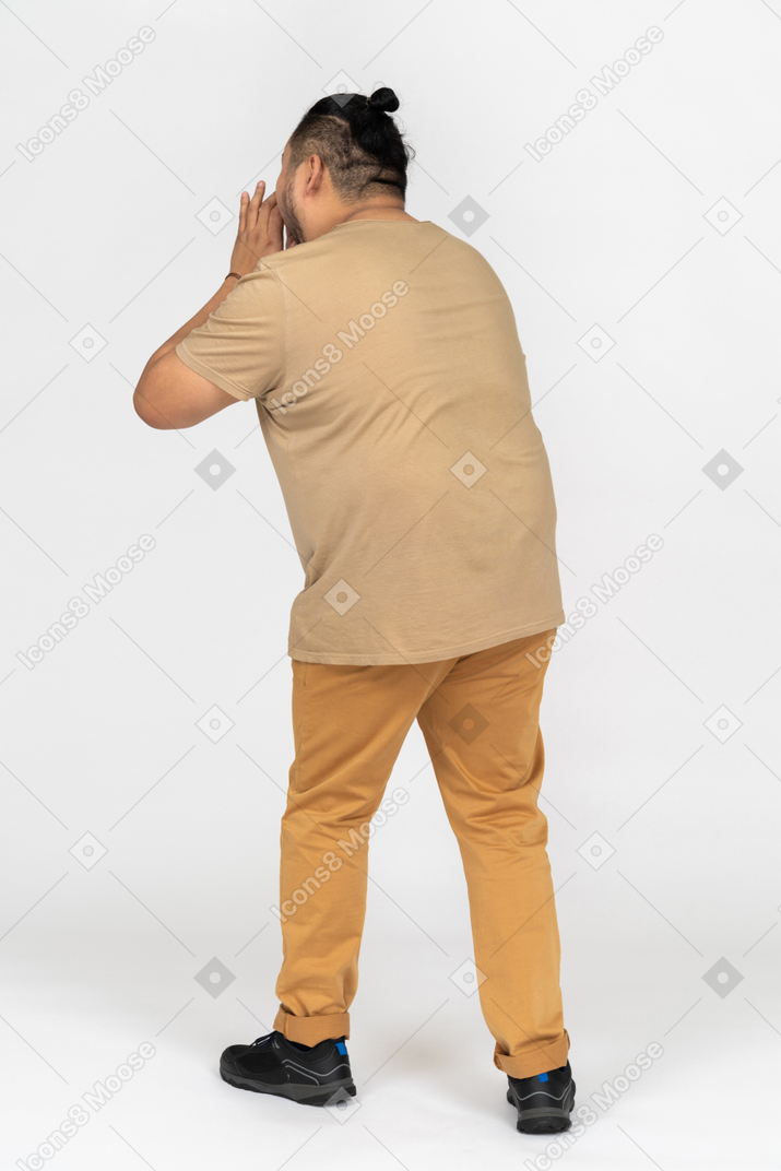 Uomo asiatico grassoccio che si tiene per mano vicino falena aperta e urlando ad alta voce