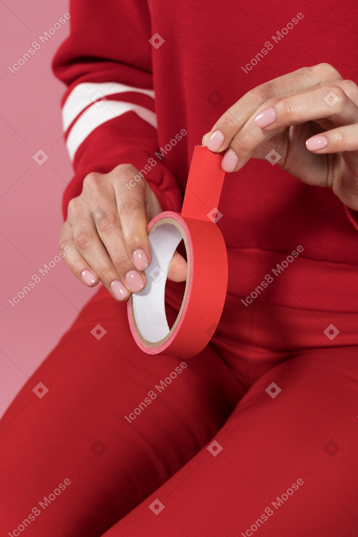 Holding a red adhesive tape