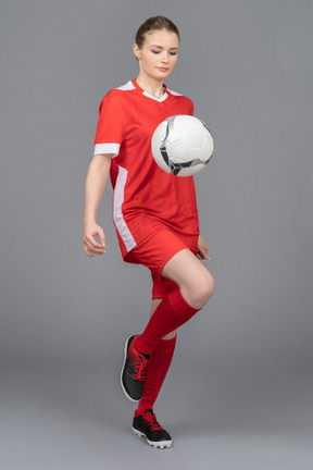 A serious female player kicking a ball