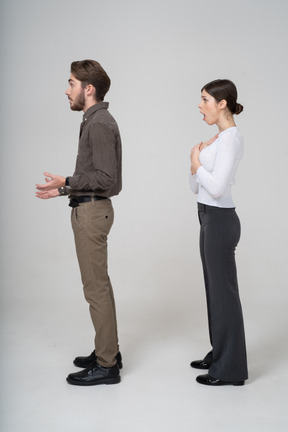 Side view of an astonished young couple in office clothing