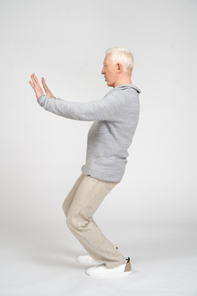 Side view of man showing stop gesture with two hands