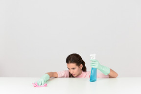 Attractive young woman dusting a surface