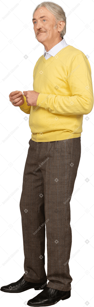 Dreiviertelansicht eines alten lächelnden mannes, der gelben pullover trägt und hände zusammenstellt