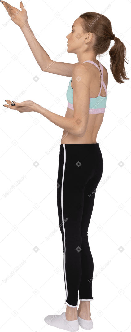 Vista posterior de tres cuartos de una jovencita en ropa deportiva levantando la mano y cuestionando