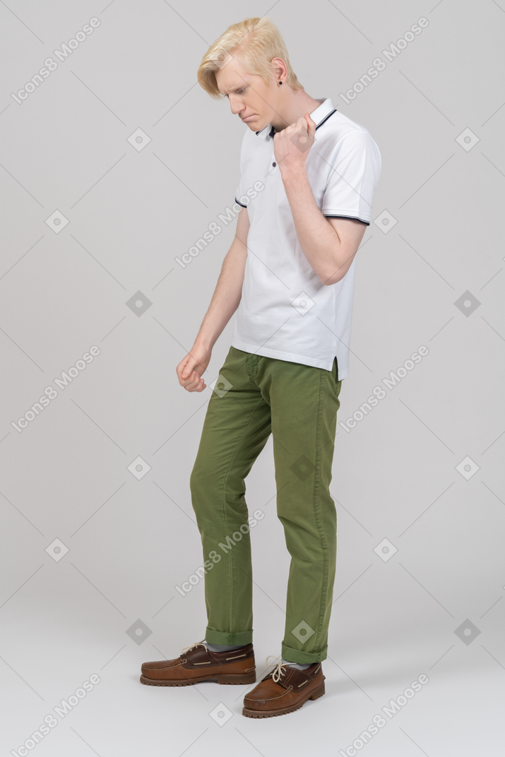 Молодой человек стоит с поднятым кулаком