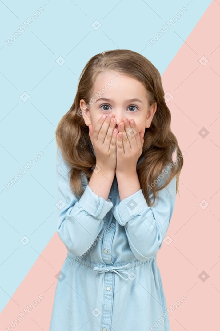 Petite fille surprise couvrant sa bouche