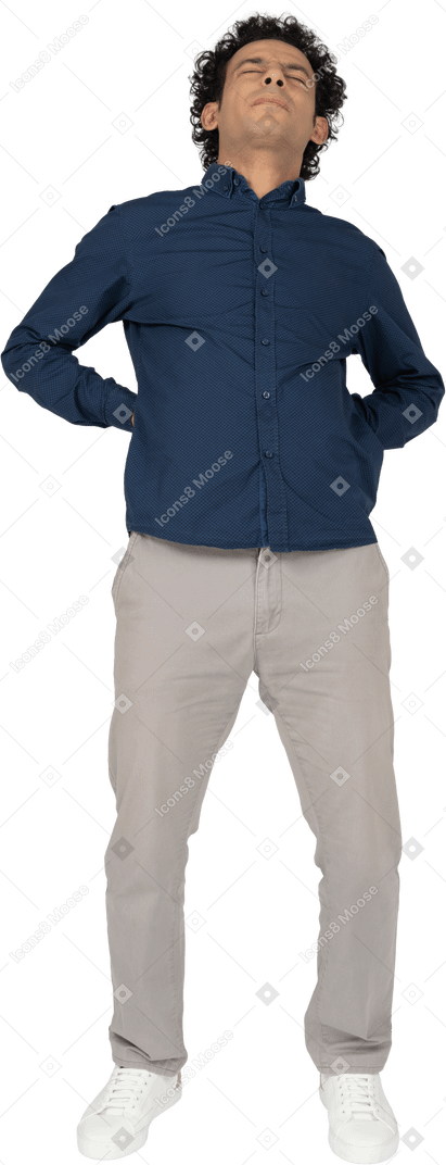 Front view of a man in casual clothes suffering from pain in lower back