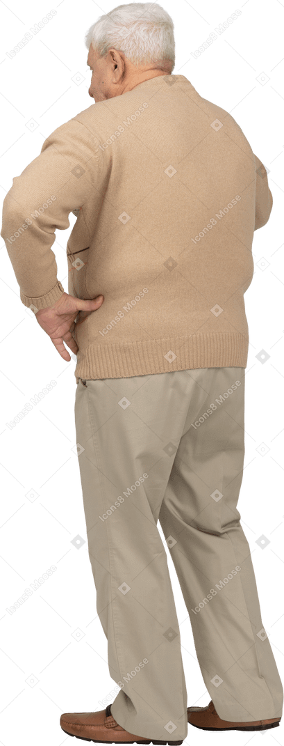 一位身穿休闲服的老人手放在臀部站立的后视图