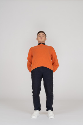 Young man in orange sweatshirt standing