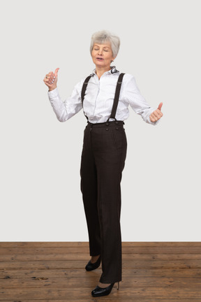 Mujer en ropa de oficina mostrando los pulgares hacia arriba