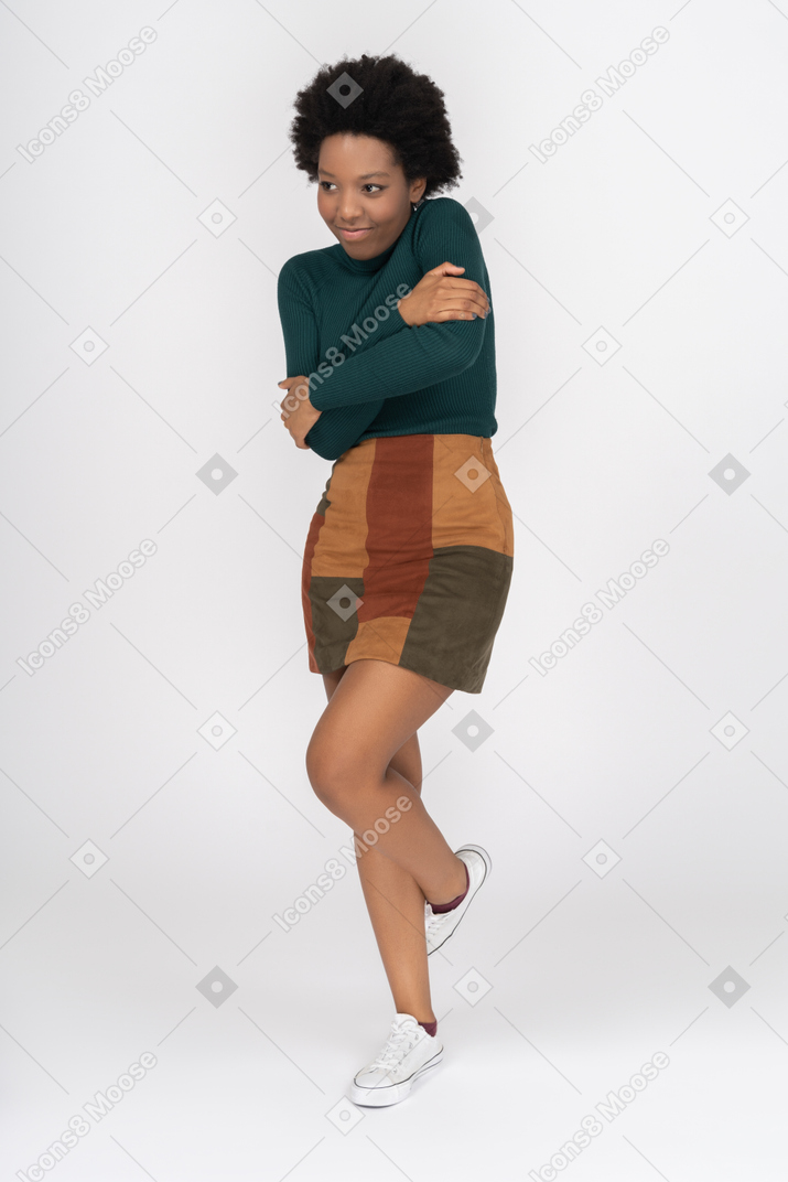 Cute african girl embracing herself and lifting one leg from a pleasure