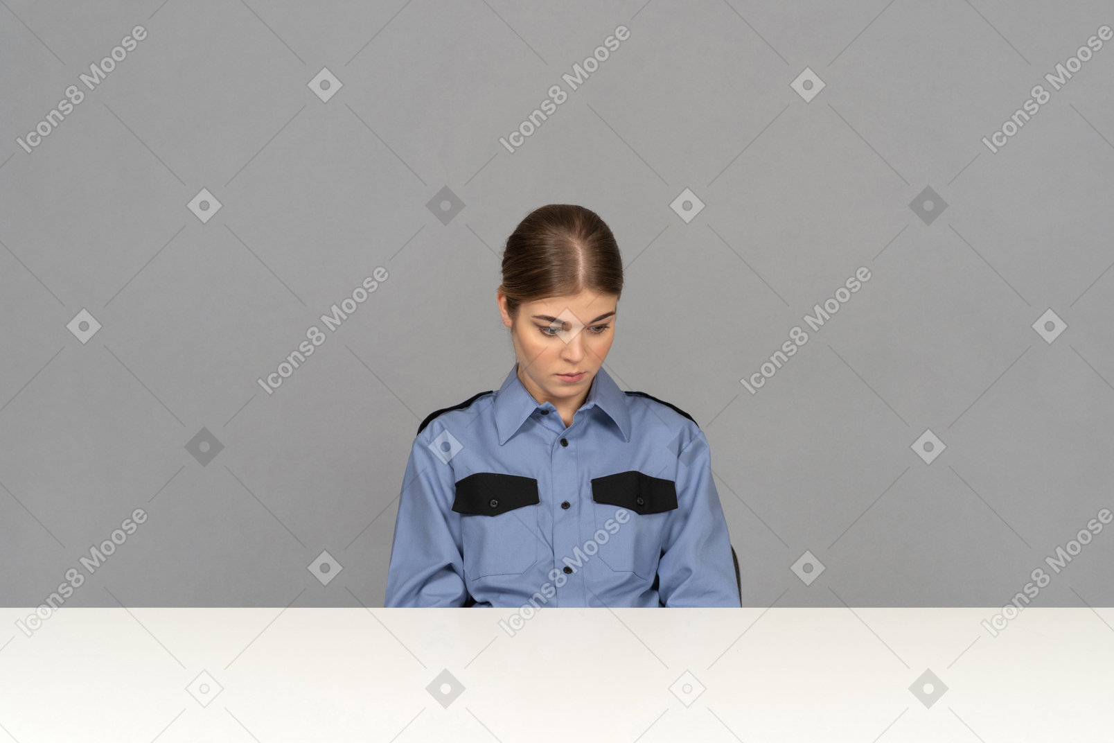 A sad female security guard sitting still