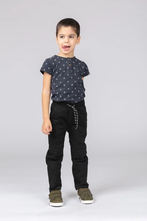 Front view of a cute boy looking at camera and showing tongue