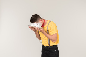 Male clown putting his face into a cake