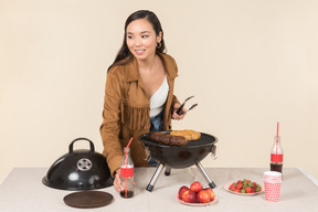 Joven mujer asiática haciendo una barbacoa